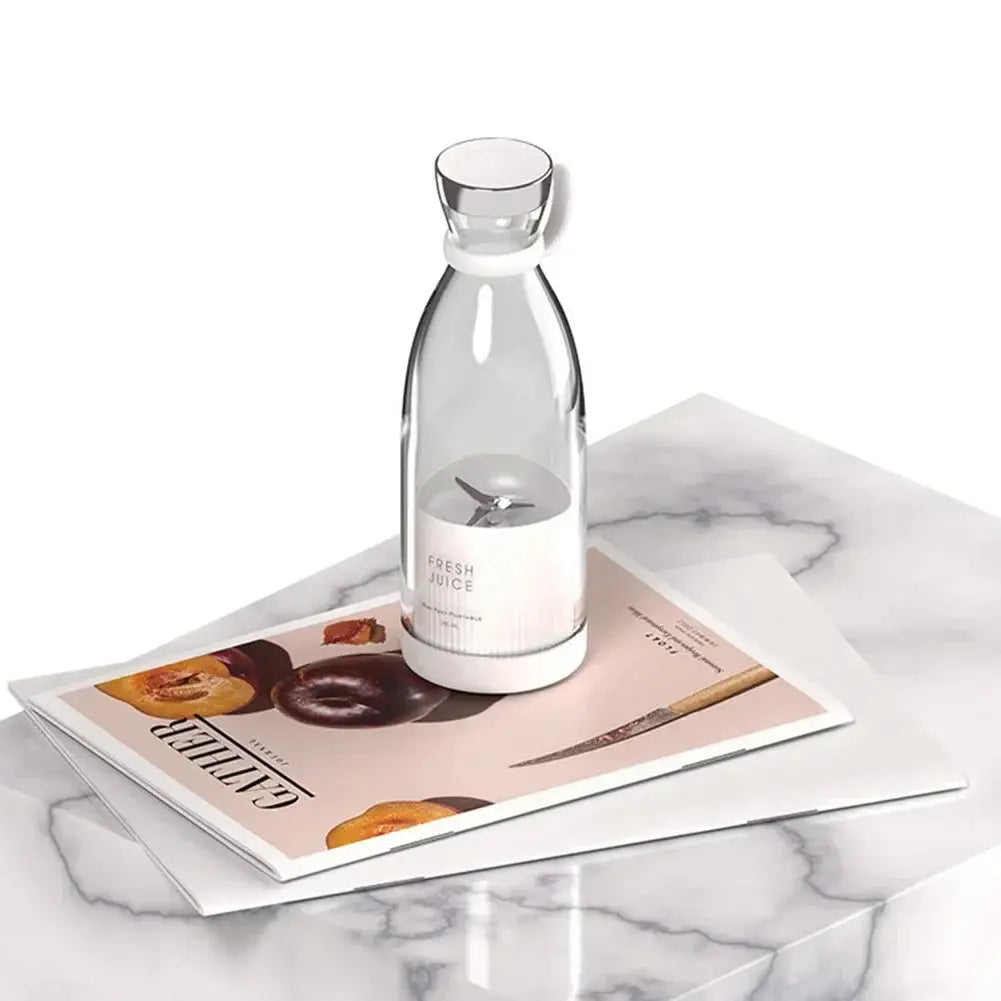 Minimalist white portable juicer blender placed on a marble surface. Perfect for stylish and convenient fresh juice preparation.